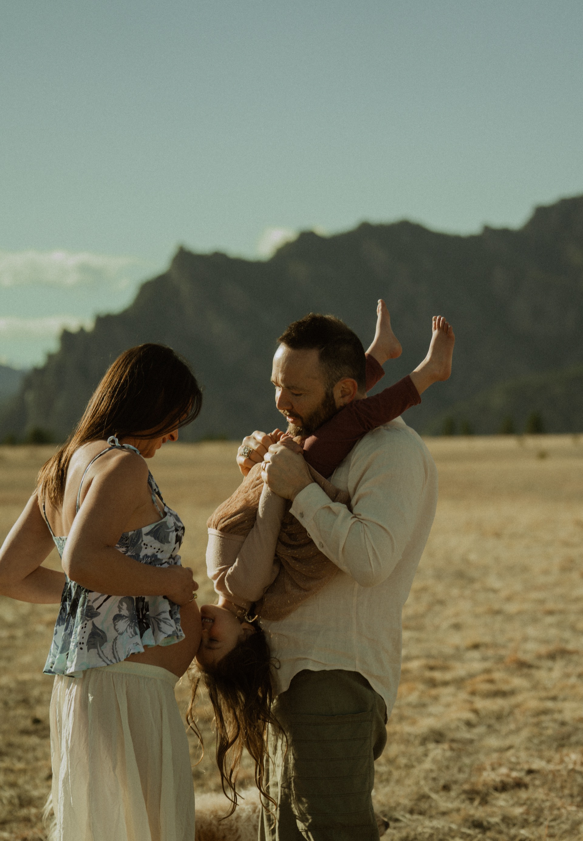 Dylan, Ra, and their daughter in front of the Flatirons