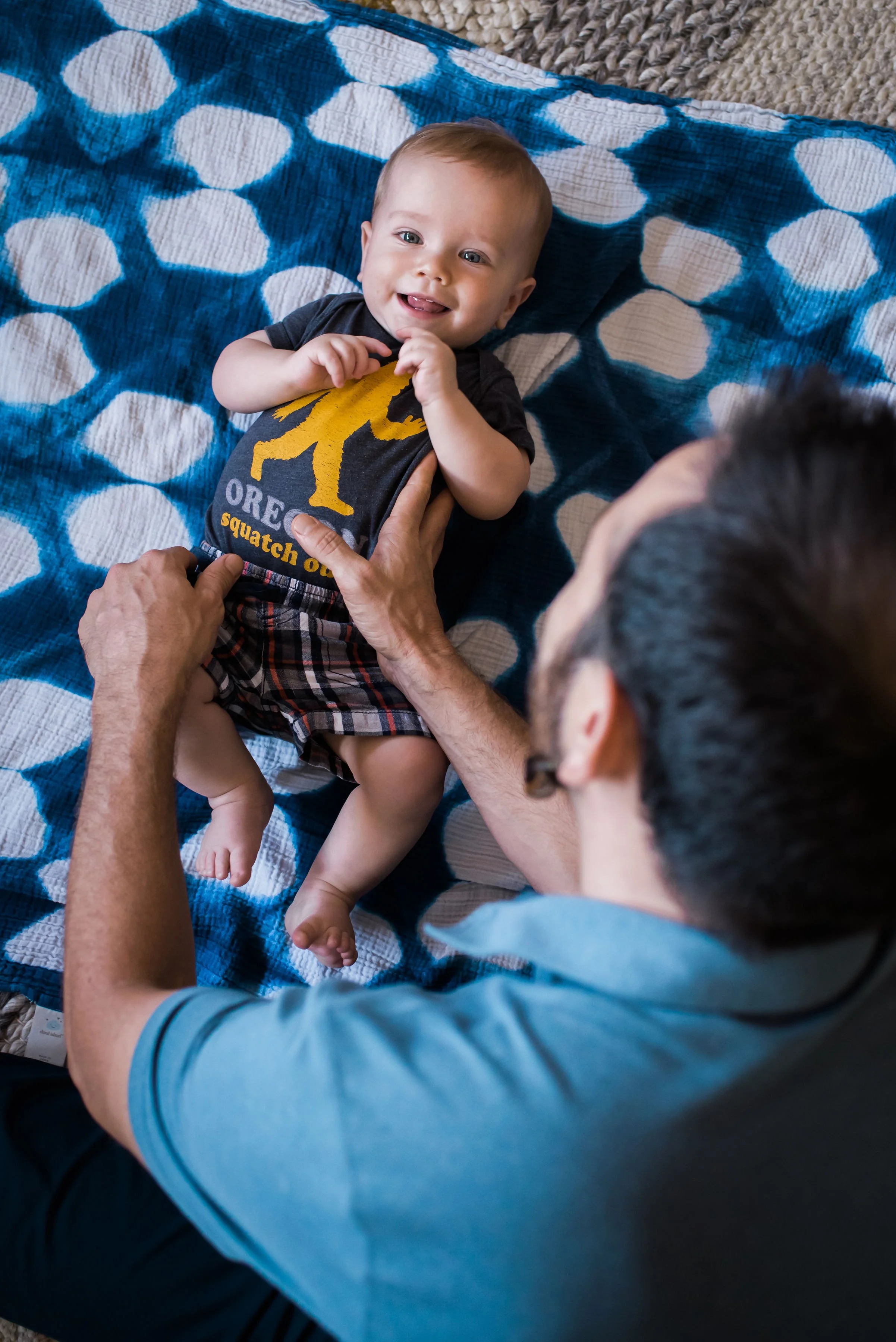 Happy baby smiling on blue blanket after adjustment